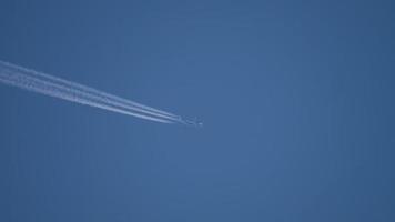 scie di condensazione nel cielo azzurro di agosto. aereo che vola alto. video