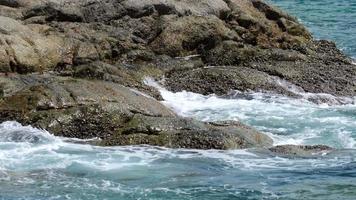 olas turquesas rodaron sobre las rocas, playa nai harn al sur de la isla de phuket, cámara lenta video
