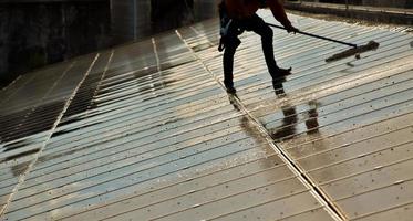 Photovoltaic technicians were cleaning and washing the surface of the solar panels which had dust and birds' pooping photo