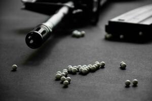 Closeup of white plastic bullets of airsoft gun or bb gun on wooden floor, soft and selective focus on white bullets. photo