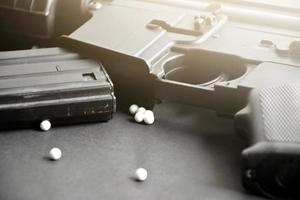 Closeup of white plastic bullets of airsoft gun or bb gun on wooden floor, soft and selective focus on white bullets. photo