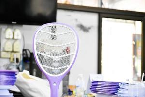 Electronic mosquito swatter in the office room for killing mosquitoes and insects inside the office, soft and selective focus. photo