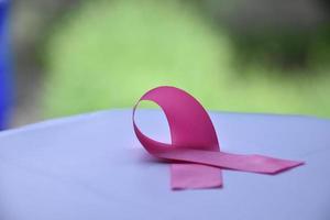 Pink ribbon on wooden table, concept for fighting against breast cancer in woman around the world. Selective focus and copy space. photo