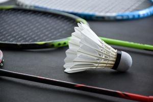 Badminton sports equipments, shuttlecocks, racket, grip, on floor of indoor badminton court. photo