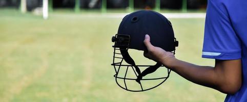 casco antiguo del deporte de cricket en la mano, concepto para los amantes del cricket de todo el mundo. foto