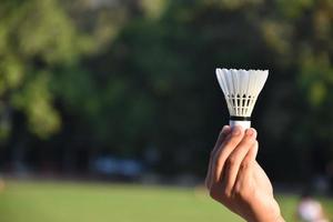 white badminton shuttlecock holding in hand. photo