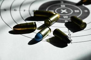 9mm bullets and 9mm bullet case on shooting target paper, soft and selective focus photo