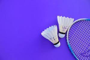 Badminton racket and white badminton shuttlecock on dark background. photo