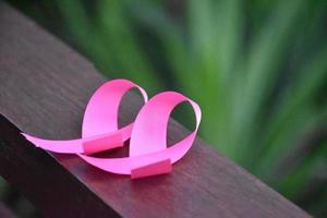 Pink ribbon on wooden table, concept for fighting against breast cancer in woman around the world. Selective focus and copy space. photo