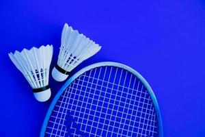 Badminton racket and white badminton shuttlecock on dark background. photo