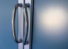 Glassdoors or front doors of the office which has stainless handlebars on their frame, soft and selective focus. photo