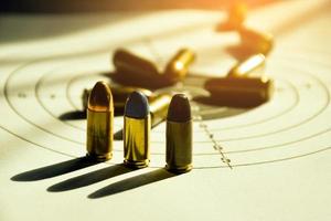 Balas de 9 mm y caja de balas de 9 mm en papel objetivo de tiro, enfoque suave y selectivo foto