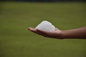 El cubo de alumbre blanco en la palma, concepto para el cuidado de la salud y el spa. foto