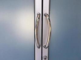 Glassdoors or front doors of the office which has stainless handlebars on their frame, soft and selective focus. photo