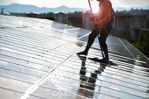 Los técnicos fotovoltaicos estaban limpiando y lavando la superficie de los paneles solares que tenían polvo y caca de pájaros. foto