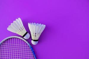 Badminton racket and white badminton shuttlecock on dark background. photo