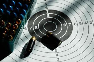 Balas de 9 mm y caja de balas de 9 mm en papel objetivo de tiro, enfoque suave y selectivo foto