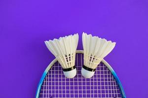 raqueta de bádminton y volante de bádminton blanco sobre fondo oscuro. foto