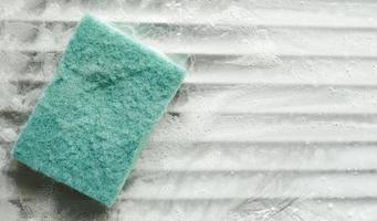 green sponge on soapy kitchen sink, copyspace photo