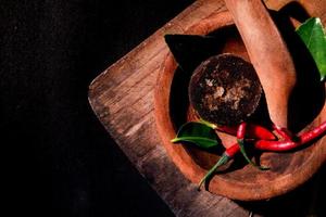 herbs on wooden mortar and pestle. brown sugar, chili photo. suitable for restaurant banner and wallpaper photo