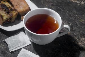 pastel de chocolate con una taza de té en tablero de madera. menú de desayuno por la mañana foto