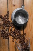 granos de café derramados sobre una tabla de madera foto