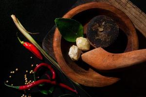 herbs on wooden mortar and pestle. brown sugar, chili photo. suitable for restaurant banner and wallpaper photo