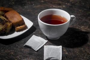 pastel de chocolate con una taza de té en tablero de madera. menú de desayuno por la mañana foto