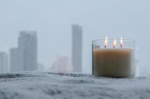 Flames burning at blurred aroma candle puts near by window in winter season. Zen and relax concept. photo