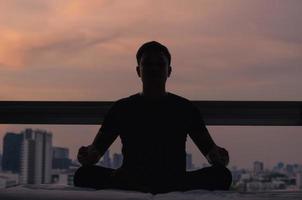 Asian man practicing meditation at home photo