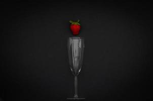 Strawberry and wineglass on dark background for minimalist flat lay black food and drink concept. photo