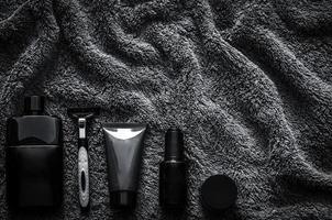 Men toiletries in modern lifestyle on dark towel background for minimalist flat lay black concept. photo