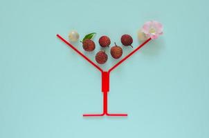 Fresh lychee fruits with stem and leaves, exotic asian fruits on pink background. photo