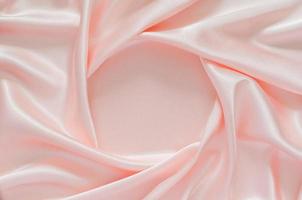 suave y elegante fondo de textura de tela satinada rosa ondulada con espacio para texto. foto