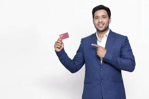 Young smiling man in pointing on credit card. photo