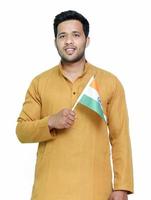 Indian boy or man in kurta holding indian national flag and showing patriotism, standing isolated background. photo