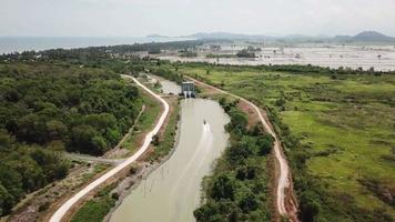 barco de vista aérea passa por uma bomba de água estreita perto de kuala muda, kedah. video