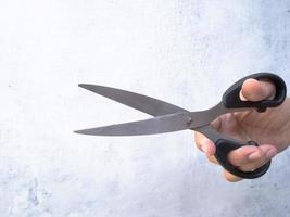 a man holding scissors in his right hand photo