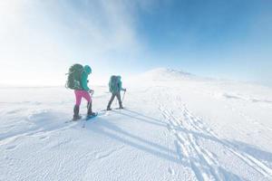 Winter mountain hiking in snowshoes photo