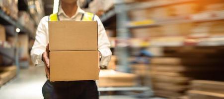 Close-up, workers carrying boxes in a large logistics warehouse. Concept of export-import logistics system. parcel box at warehouse, packaging, delivery, warehouse, banner image