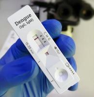 Technician glove hand hold rapid test cassette for dengue IgG, IgM rapid screening test showing positive IgG test. photo