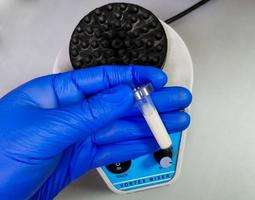 Medical scientist hold Lipemic blood sample in laboratory, high Triglyceride contain serum sample photo