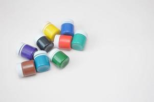 Jars with different colors of gouache isolated on white background. Drawing, art, teaching, paint production. photo