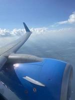 Flying airplane, large airplane wing and jet turbine photo