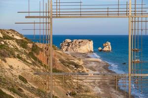 Petra tou Romiou, Aphrodite's birthplace in Paphos, Cyprus behind a framed construction photo