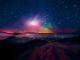 Milky Way and pink light at mountains. Night colorful landscape. Starry sky with hills. Beautiful Universe. Space background with galaxy. Travel background photo