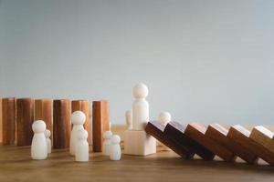 Risk management and business strategy concept, businessman hands stop the dominoes from falling continuously, preventing future risks from crisis. photo