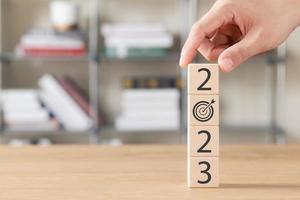 2023 new year goal planning idea, wood block cube with new year 2023 and target icon, business vision. photo