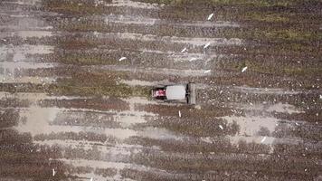 Bird eye view descending tractor cultivate the soil. video
