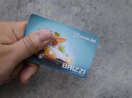 Sidoarjo, Jawa timur, Indonesia, 2022 - a man holding a bank bri e-money card in hand photo